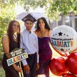 Cérémonie de graduation avec ballons imprimés personnalisés, décor aux couleurs de l’établissement et diplômés célébrant leur réussite.